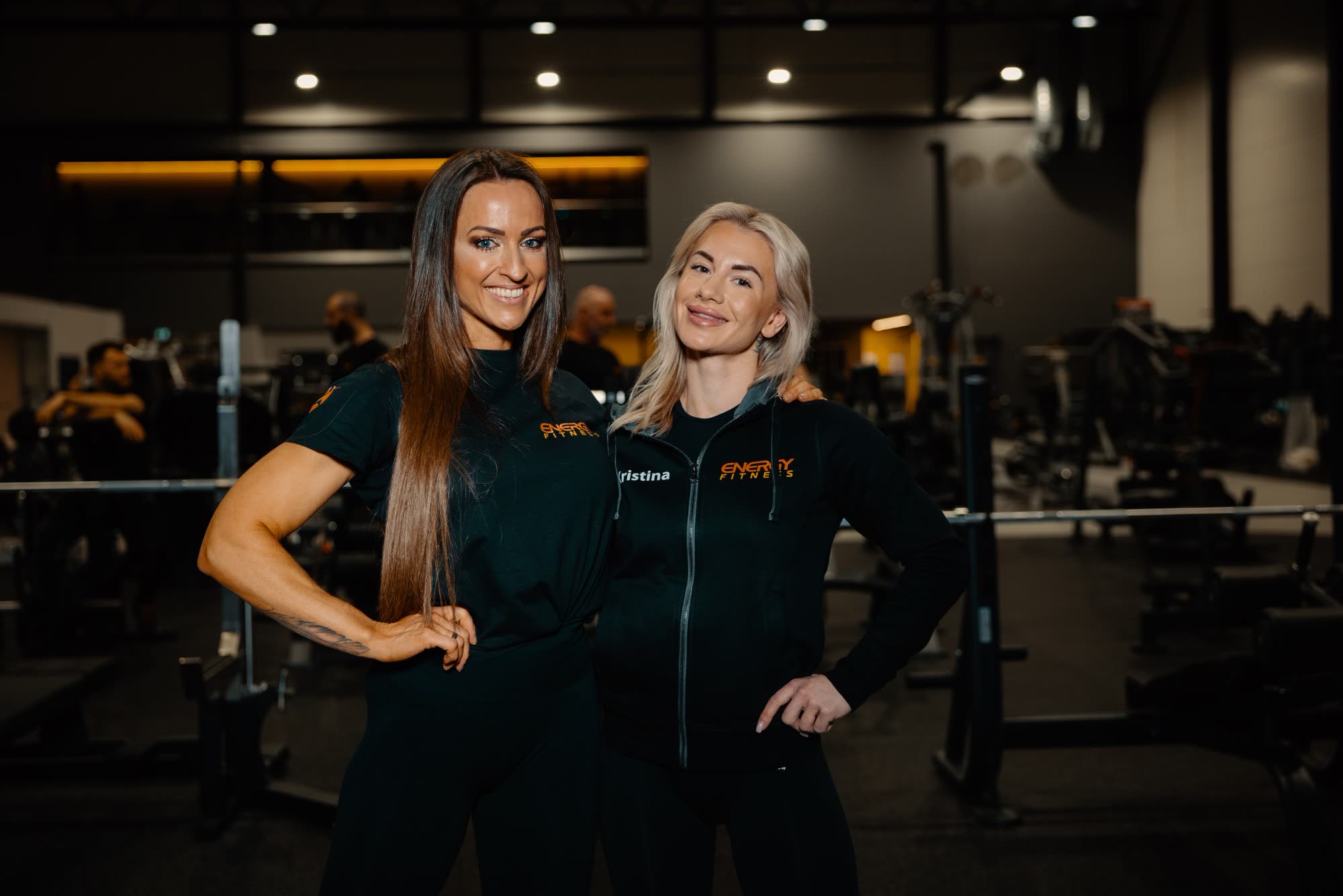 To trenere fra ENERGY Fitness i svarte treningsklær i et treningssenter